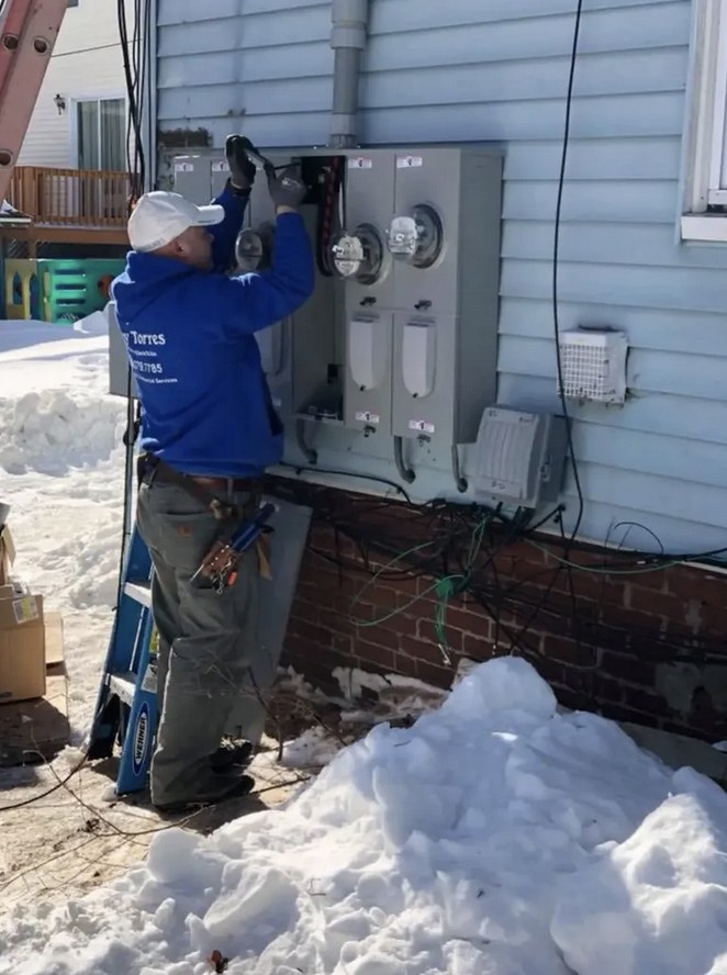 Sonny Torres working on an exterior electrical panel in Milford, MA