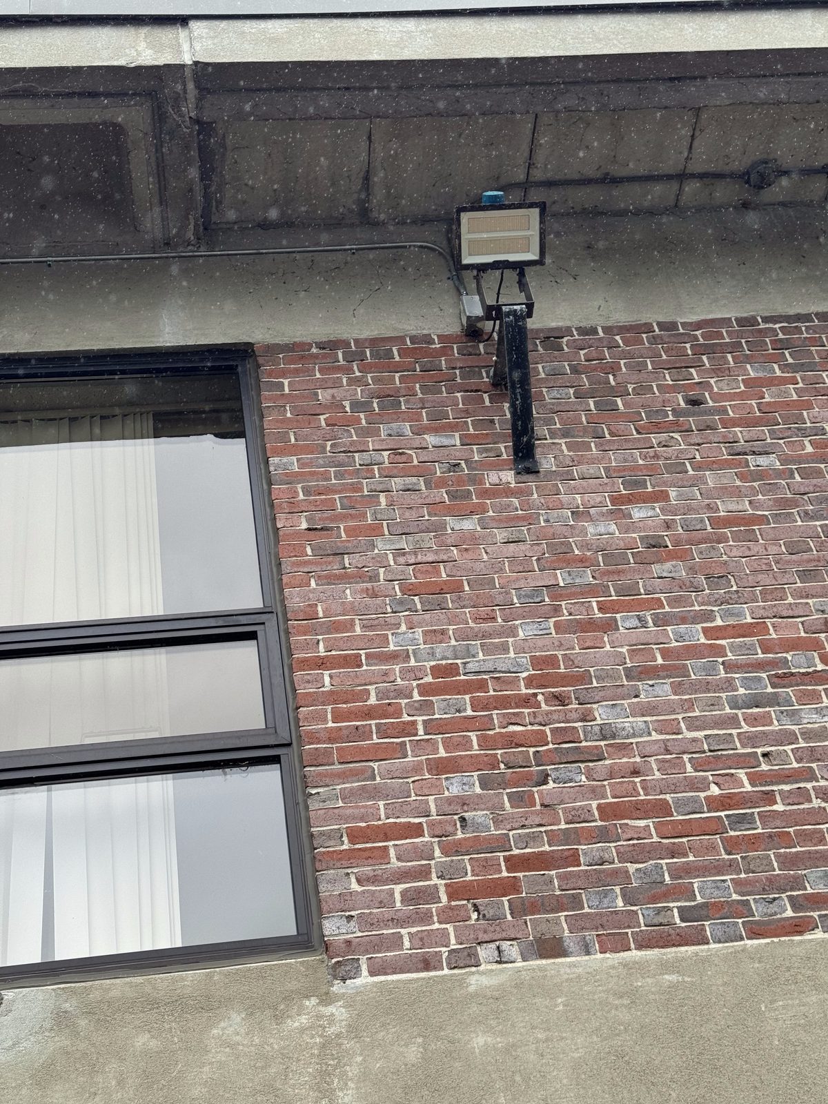 Flood light installation on exterior brick wall by Sonny Torres Electrician